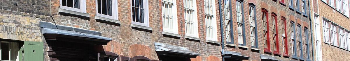 Brick town houses with sash windows and shop awnings along a street