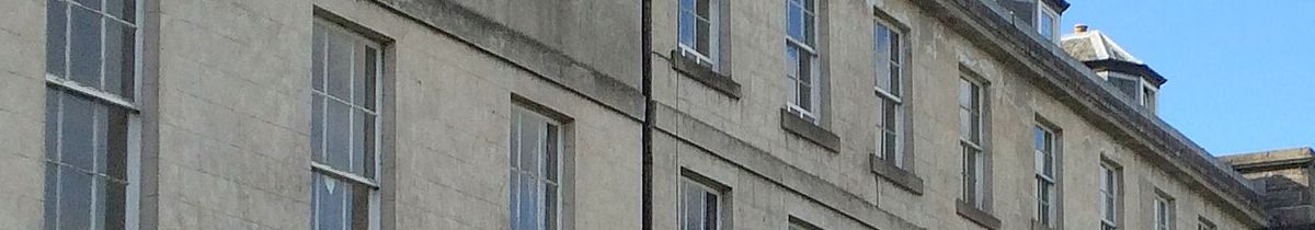 Pale stone Georgian terrace with tall sash windows under a clear sky