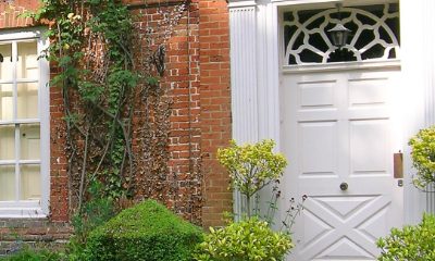 Panelled white front door with fanlight in a brick and flint house front