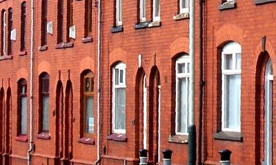 Front elevations of red-brick terraced houses with arched window heads
